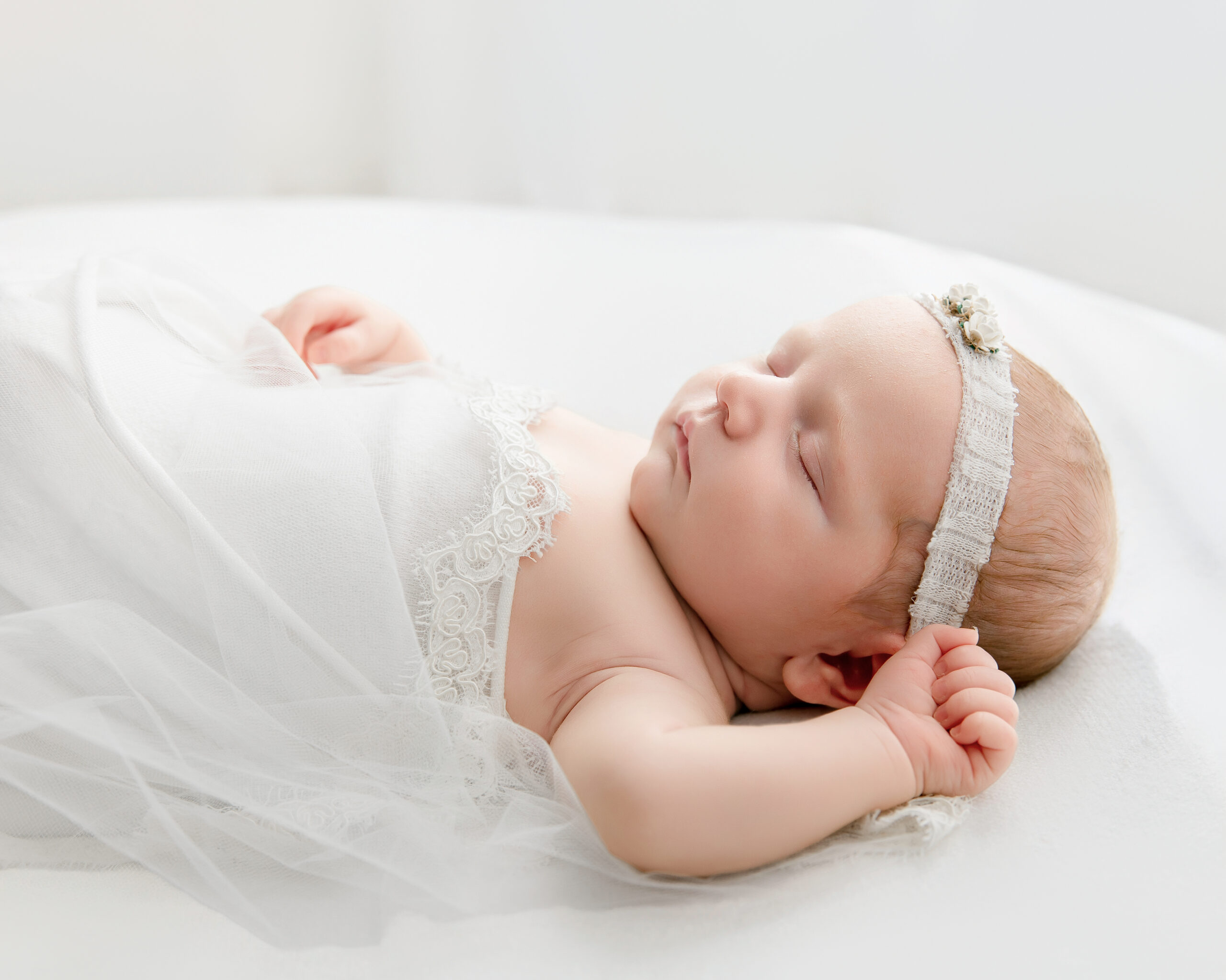 A sleeping newborn wrapped in fabric at Erika Kelly Photography's Covington studio